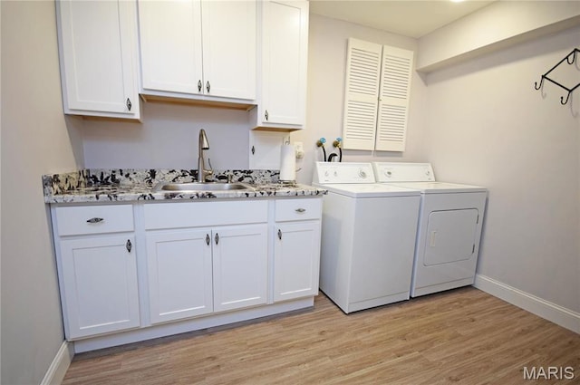 washroom with independent washer and dryer, light wood-style floors, and baseboards