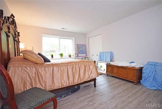 bedroom with wood finished floors and a closet