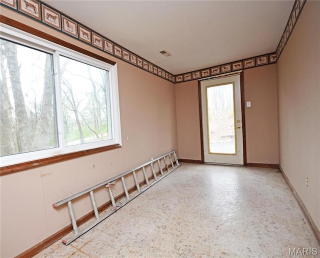 spare room featuring healthy amount of natural light and baseboards