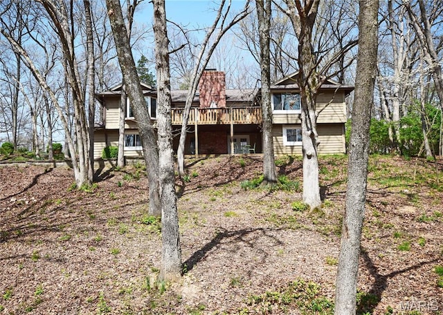 back of property with a deck and a chimney