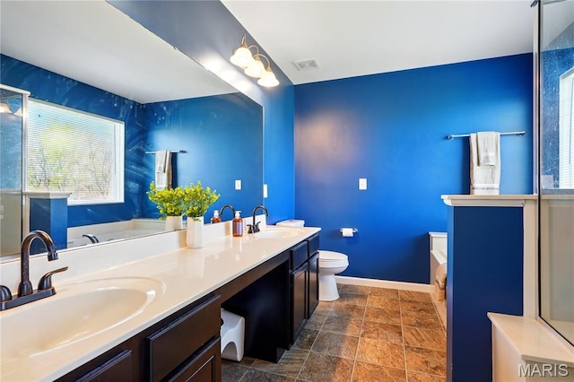 1914 Teresa Fields Ln, Lake St Louis, MO 63367 - bathroom featuring baseboards, stone finish flooring, a bath, double vanity, and toilet