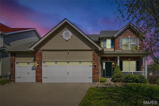 1914 Teresa Fields Ln, Lake St Louis, MO 63367 - view of front of house featuring driveway, brick siding, a garage, covered porch, and a yard