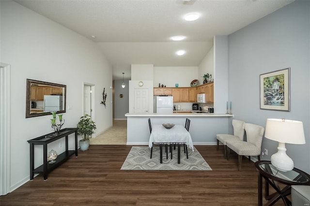 173 Silo View Dr Unit 393A, Wentzville, MO 63385 - kitchen featuring white appliances, vaulted ceiling, a peninsula, dark wood finished floors, and light countertops