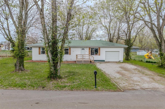 1425 Cedar Dr, Lebanon, MO 65536 - single story home with dirt driveway, metal roof, an attached garage, and a front yard