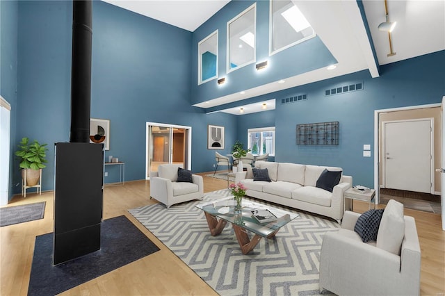 5089 Waterman Blvd, Saint Louis, MO 63108 - living area featuring a wood stove, wood finished floors, and a high ceiling