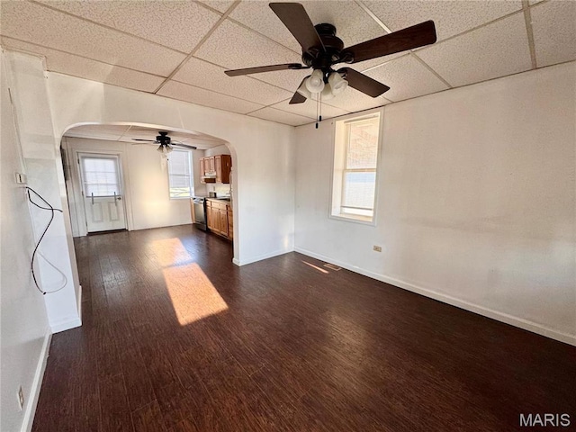 1001 S Central Ave, Vandalia, MO 63382 - unfurnished room with arched walkways, a paneled ceiling, a ceiling fan, dark wood-type flooring, and baseboards