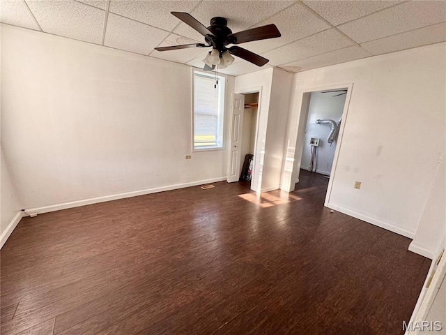 1001 S Central Ave, Vandalia, MO 63382 - unfurnished bedroom with a drop ceiling, dark wood-style flooring, baseboards, a ceiling fan, and a closet