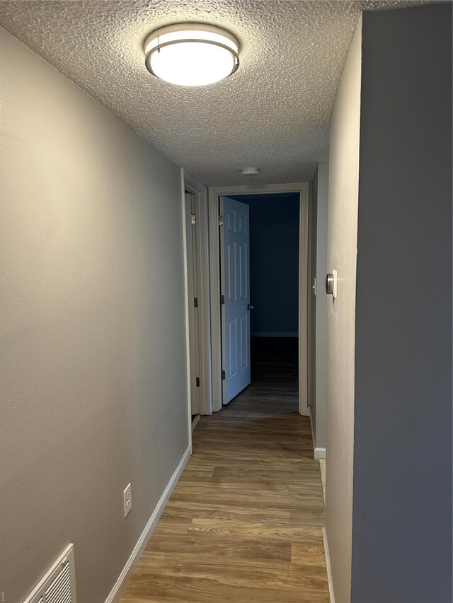 1459 Bobolink Pl, Saint Louis, MO 63144 - corridor with a textured ceiling, wood finished floors, and baseboards