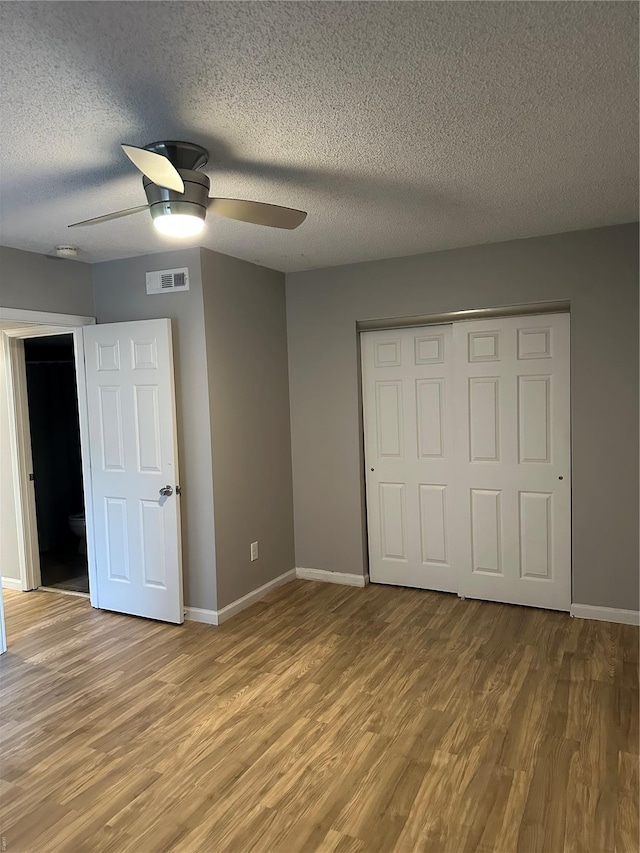 1459 Bobolink Pl, Saint Louis, MO 63144 - unfurnished bedroom with light wood-style flooring, baseboards, a closet, and a textured ceiling