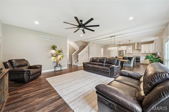 living area with stairway, ceiling fan, recessed lighting, dark wood finished floors, and baseboards