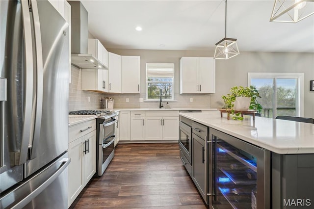 kitchen featuring appliances with stainless steel finishes, beverage cooler, wall chimney range hood, backsplash, and recessed lighting
