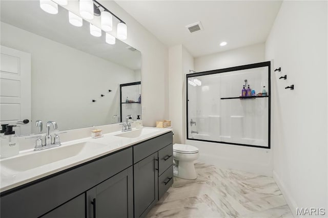 full bath with double vanity, enclosed tub / shower combo, toilet, marble finish flooring, and baseboards