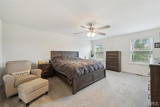 bedroom with light colored carpet, baseboards, and ceiling fan
