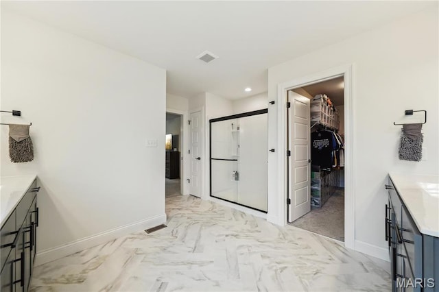 full bathroom with vanity, a shower stall, marble look tiles, baseboards, and recessed lighting