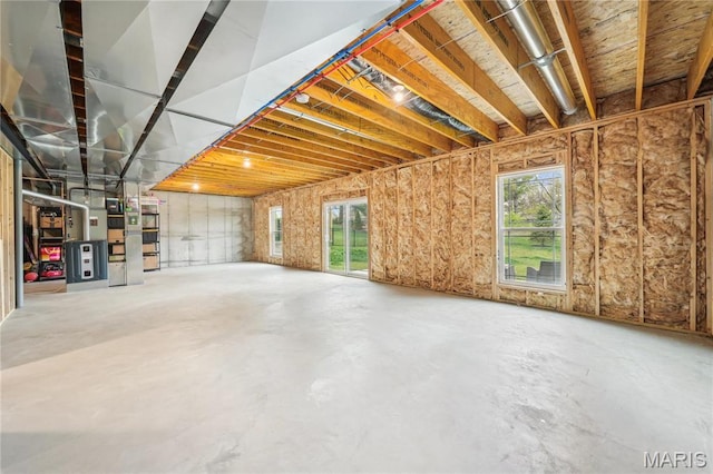 basement featuring heating unit and plenty of natural light