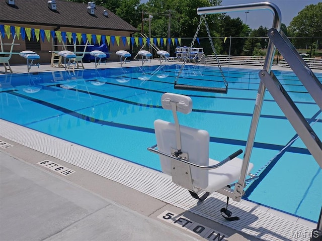 view of swimming pool featuring fence