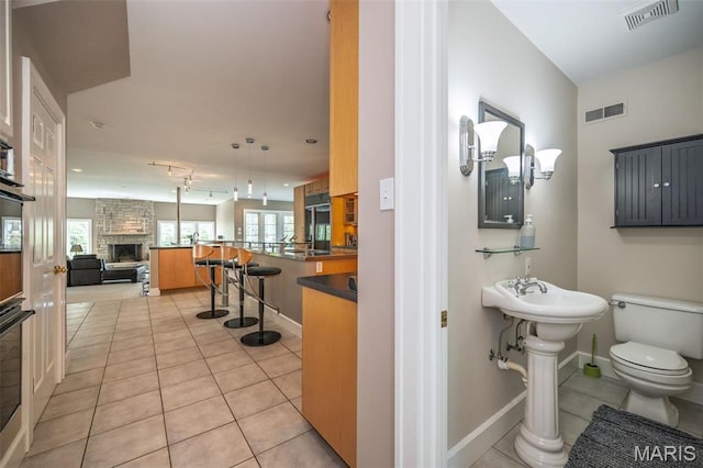 1211 S Geyer Rd, Saint Louis, MO 63122 - bathroom with tile patterned flooring, toilet, baseboards, and a fireplace