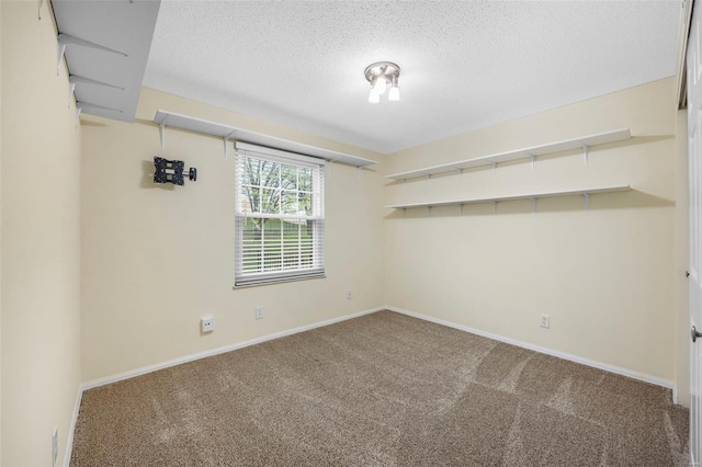 unfurnished room with carpet floors, a textured ceiling, and baseboards