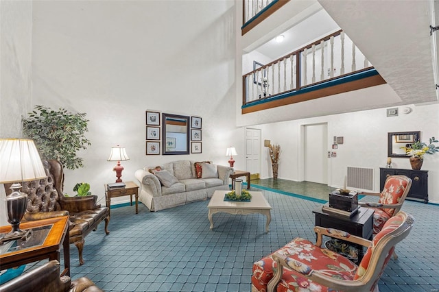 living area with a towering ceiling, carpet flooring, and baseboards