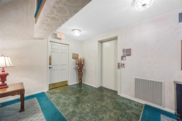 hall with a textured ceiling, tile patterned floors, and baseboards
