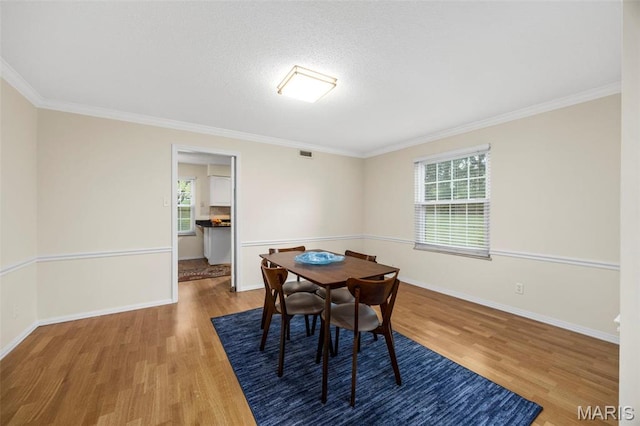 15038 Claymoor Ct Unit 2, Chesterfield, MO 63017 - dining space featuring wood finished floors, plenty of natural light, crown molding, baseboards, and a textured ceiling