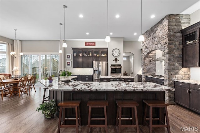 408 Hamlet Ct, Lake St Louis, MO 63367 - kitchen featuring a large island, appliances with stainless steel finishes, a breakfast bar area, dark wood-style flooring, and recessed lighting
