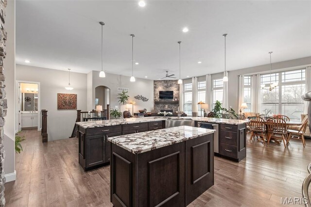 408 Hamlet Ct, Lake St Louis, MO 63367 - kitchen featuring a spacious island, stainless steel dishwasher, ceiling fan, wood finished floors, and dark brown cabinets