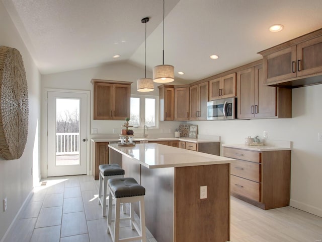 504 Timber View Ter, Hannibal, MO 63401 - kitchen featuring stainless steel microwave, a sink, baseboards, a center island, and vaulted ceiling