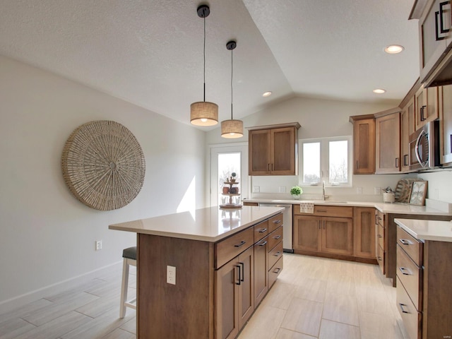 504 Timber View Ter, Hannibal, MO 63401 - kitchen with appliances with stainless steel finishes, a breakfast bar, a sink, lofted ceiling, and brown cabinets
