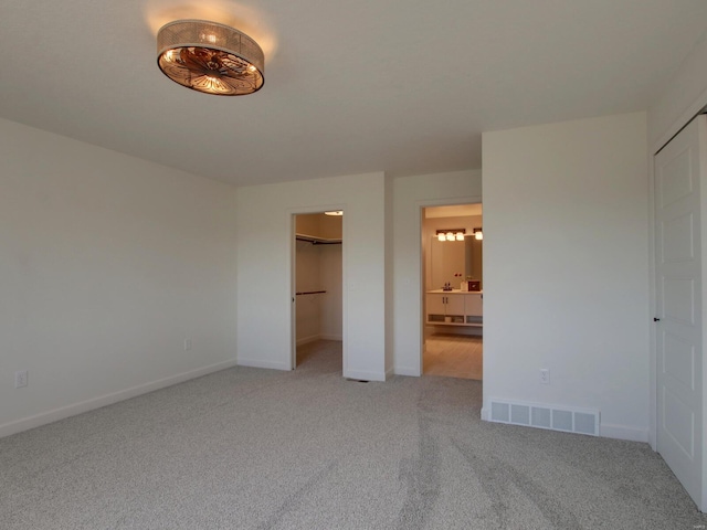 504 Timber View Ter, Hannibal, MO 63401 - unfurnished bedroom with light carpet, baseboards, ensuite bathroom, and a walk in closet