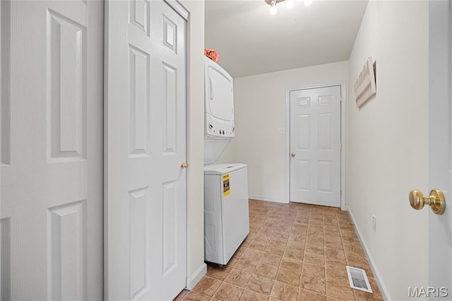 918 Fairway Dr, Union, MO 63084 - laundry room featuring stacked washing machine and dryer, baseboards, and light stone finish flooring