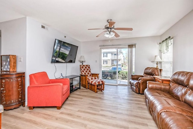 living area featuring light wood-style floors and a ceiling fan