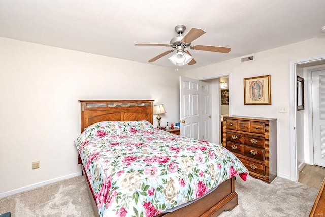 bedroom with light colored carpet, baseboards, and a ceiling fan