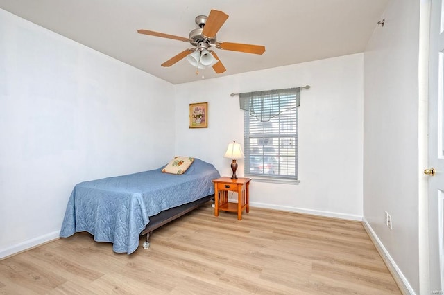 bedroom featuring light wood-style flooring, baseboards, and ceiling fan
