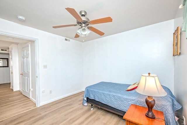 bedroom with light wood finished floors, baseboards, and a ceiling fan