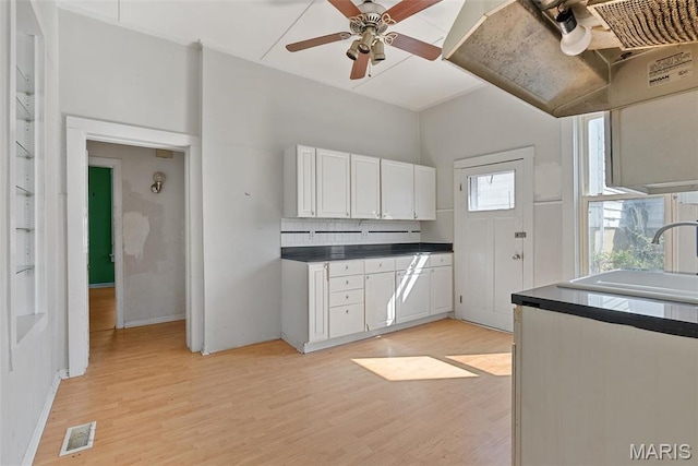 104 S 4th St, De Soto, MO 63020 - kitchen featuring white cabinetry, dark countertops, light wood-style floors, a ceiling fan, and extractor fan