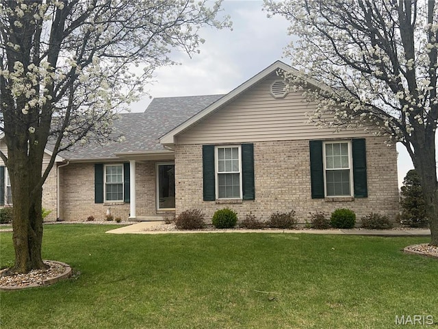 ranch-style house with brick siding, a front lawn, and a shingled roof