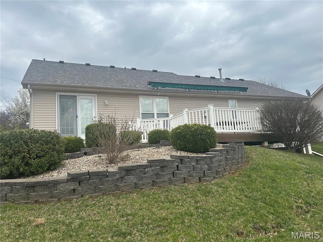 rear view of house with a wooden deck and a yard