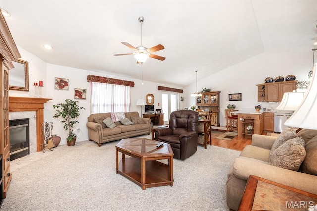 living room with a ceiling fan, lofted ceiling, and a high end fireplace
