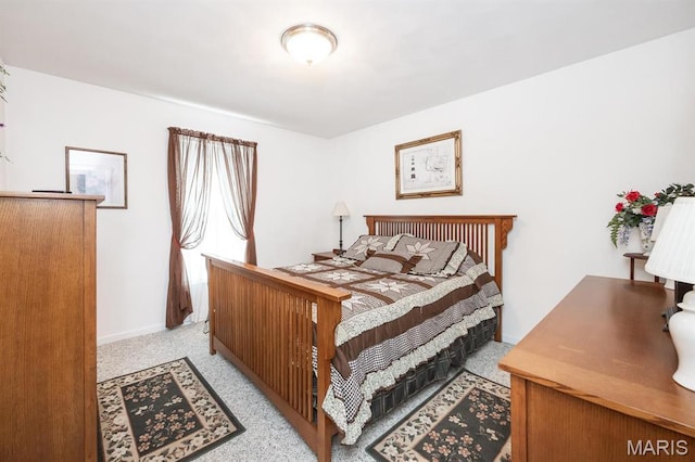 bedroom featuring light colored carpet and baseboards