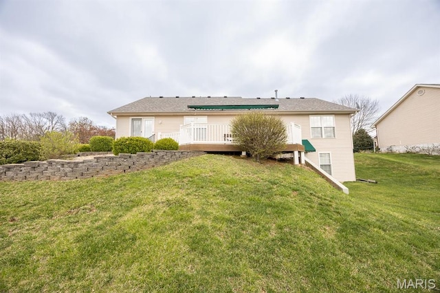 rear view of house with a wooden deck and a yard
