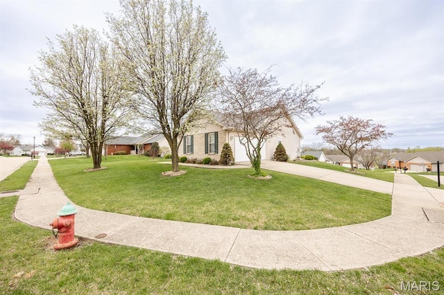 view of front facade with driveway, a front yard, an attached garage, and a residential view