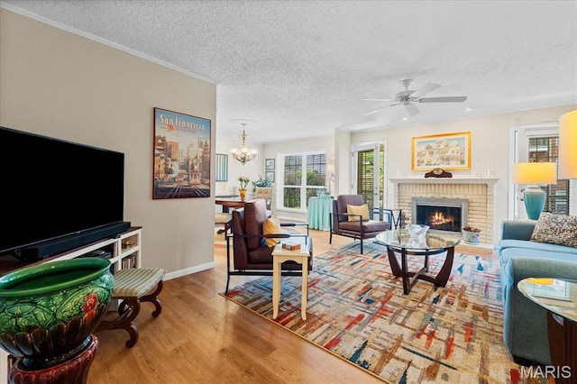 10358 Chimney Rock Dr Unit 2, Saint Louis, MO 63146 - living area featuring a textured ceiling, wood finished floors, a brick fireplace, ceiling fan, and baseboards