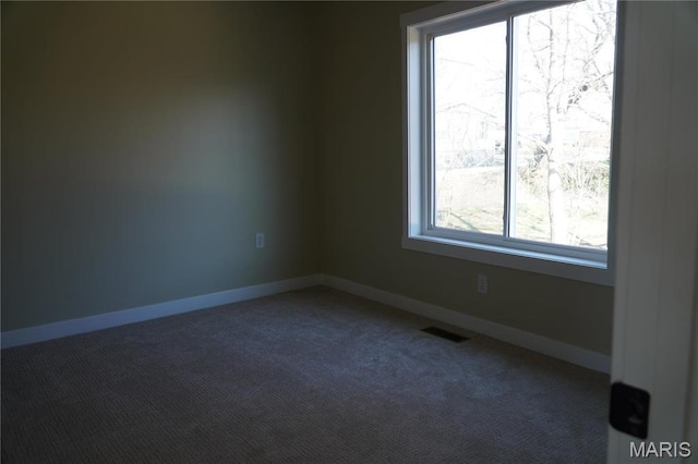 spare room featuring carpet flooring and baseboards