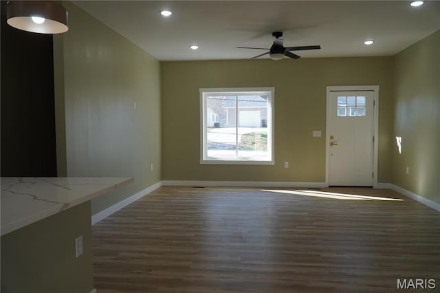 unfurnished living room with dark wood finished floors, a ceiling fan, recessed lighting, and baseboards