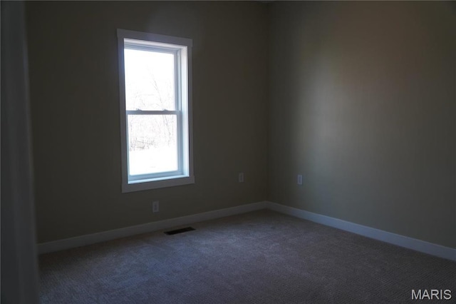 unfurnished room with carpet flooring and baseboards