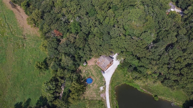 aerial view of property and surrounding area with a forest and a large body of water