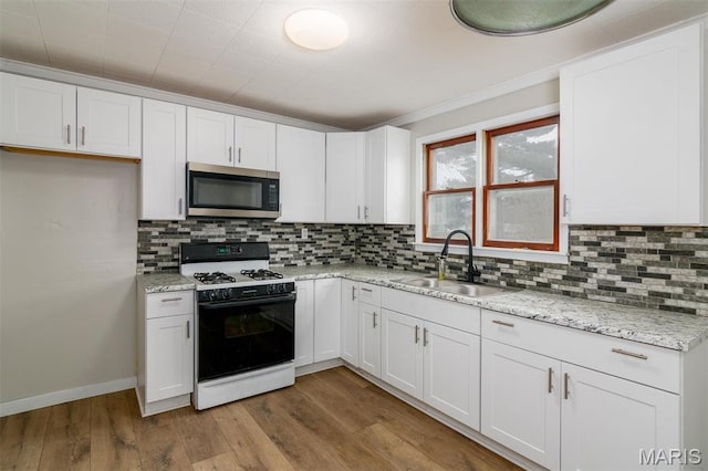 800 Frey St, Gillespie, IL 62033 - kitchen featuring stainless steel microwave, gas stove, a sink, and white cabinetry