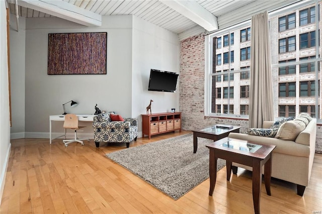 living area featuring beamed ceiling, hardwood / wood-style flooring, baseboards, and wood ceiling