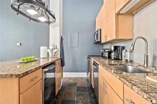 kitchen with beverage cooler, appliances with stainless steel finishes, light brown cabinetry, a sink, and dark stone counters